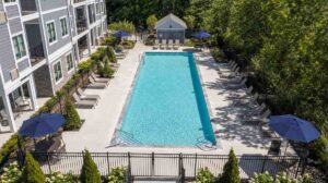 Aerial view of a compliant commercial swimming pool at a New England condominium complex with safety fencing and proper equipment